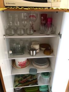 a cupboard filled with dishes and other kitchen items at Apartamento confortável in Rio de Janeiro