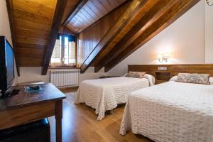a room with two beds and a television in a room at Esera Room in Benasque