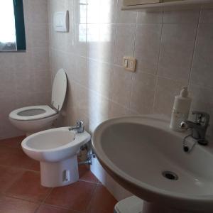 een badkamer met een witte wastafel en een toilet bij Agriturismo la Martina in Macchiascandona