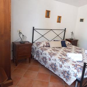 een slaapkamer met een bed en een houten nachtkastje en een bed sidx sidx sidx bij Agriturismo la Martina in Macchiascandona