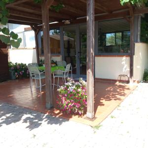 een patio met een tafel, stoelen en bloemen bij Agriturismo la Martina in Macchiascandona