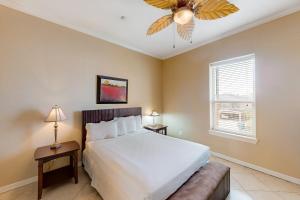 a bedroom with a bed and a ceiling fan at Escape Condominiums #7 in South Padre Island +9 photos