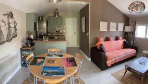 a living room with a table and a couch at Chalet tout équipé, terrasse in Gujan-Mestras