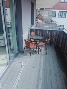 patio z 2 krzesłami i stołem na balkonie w obiekcie Apartament4U - Olimpijskie Ogrody w mieście Suwałki