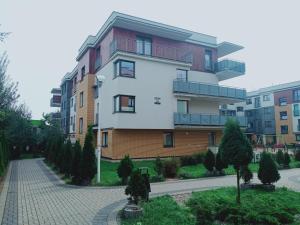 budynek na ulicy z drzewami przed nim w obiekcie Apartament4U - Olimpijskie Ogrody w mieście Suwałki