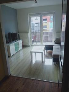 salon ze stołem i kanapą w obiekcie Apartament4U - Olimpijskie Ogrody w mieście Suwałki