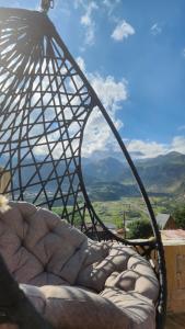 una sedia con vista sulle montagne sullo sfondo di Hotel Toliketi a Kazbegi