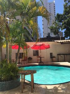 una piscina con banco y palmeras en Hotel Italia Beach, en Fortaleza