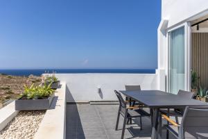a patio with a table and chairs and the ocean at Private Penthouse with Heated Spa Bath Pembroke St Julians in Pembroke