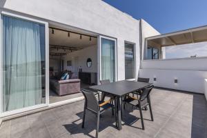 Un comedor con mesa y sillas en un balcón. en Heated Luxury Poolside Retreat in St Julian s, en Pembroke