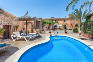 a villa with a swimming pool and a patio at Casa Antigua in Santanyi