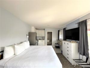 Winfield的住宿－湖濱鄉村速8汽車旅館- 溫菲爾德地區，卧室配有一张白色大床和电视。