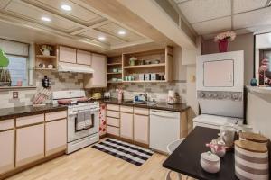 a kitchen with white appliances and a table in it at Barbie's Dream Apt in the City in Sacramento