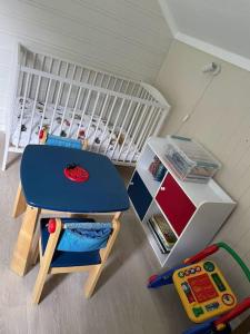 a childs room with a table and a crib at Høgset in Austefjorden