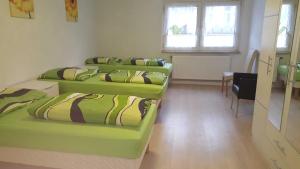 four beds in a room with a table and a window at holiday apartment essen 3 in Essen