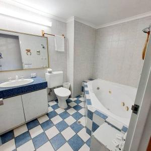 a bathroom with a tub and a toilet and a sink at Villa 2 Pool Spa Beach Sea! in Mandurah