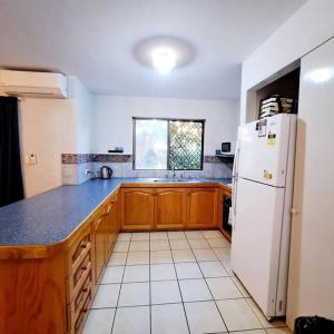 a kitchen with a white refrigerator and a window at Villa 2 Pool Spa Beach Sea! in Mandurah