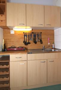 a kitchen with wooden cabinets and a sink and utensils at Ferienappartement K312 für 2-3 Personen in Strandnähe in Brasilien