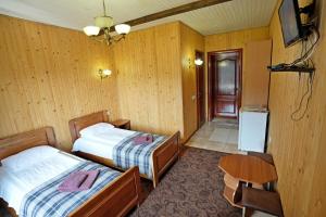 a bedroom with two beds and a table and a chair at Villa Loiza in Bukovel