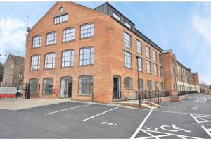 a brick building with a parking lot in front of it at Luxury Northampton Town Centre Apartment in Northampton