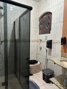 uma casa de banho com um chuveiro e um WC. em Quarto duplo em Belo Horizonte
