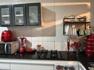 uma cozinha com uma bancada com um micro-ondas e um fogão em Quarto duplo em Belo Horizonte