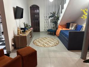 a living room with a blue couch and a tv at Quarto duplo in Belo Horizonte