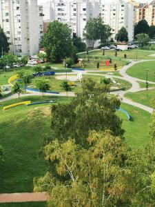 ein Park in einer Stadt mit Gebäuden im Hintergrund in der Unterkunft Apartman Enio in Vukovar
