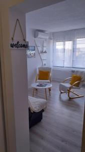 sala de estar con sillas amarillas y mesa en Apartman Enio en Vukovar