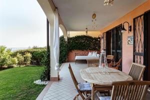 een patio met een tafel en stoelen en een bed bij la "PERLA", con vista sul Lago di Garda in Padenghe sul Garda