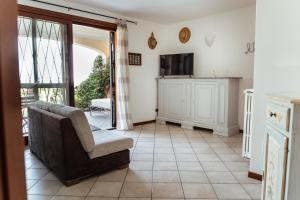 Una sala de estar con un sofá y un televisor. en la "PERLA", con vista sul Lago di Garda, en Padenghe sul Garda
