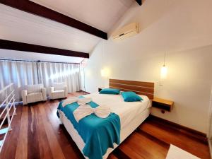 a bedroom with a bed with blue and white sheets at Pousada Areia e Mar in Ubatuba