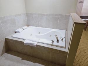 a bathroom with a bath tub with a sink at Cobblestone Inn & Suites - Bloomfield in Bloomfield