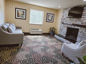 a living room with a couch and a fireplace at Cobblestone Inn & Suites - Bloomfield in Bloomfield