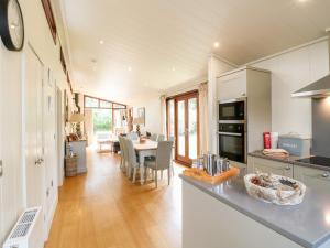 a kitchen and living room with a table and chairs at Clipsham in Cottesmore