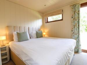 a bedroom with a large white bed with a window at Clipsham in Cottesmore