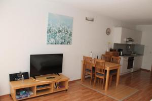 a living room with a television and a table with chairs at Ferienappartement K315 für 2-4 Personen in Strandnähe in Schönberg in Holstein