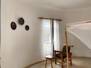 una habitación con una silla y relojes en la pared en Rafiki Safari Lodge Bwindi en Kinkizi