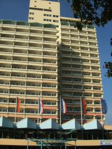 um edifício alto com bandeiras à frente em Ostseeappartement K014 em Brasilien