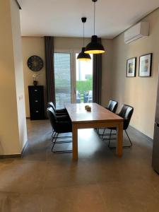 jadalnia z drewnianym stołem i krzesłami w obiekcie Sunset Bay Villa at Gjiri Lalzit Durres w Durrës