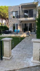 a large house with a stone patio in front of it at Sunset Bay Villa at Gjiri Lalzit Durres in Durrës