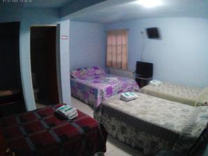 a bedroom with two beds and two ottomans at Lago Buenos Aires in Perito Moreno