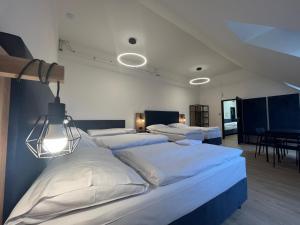 a bedroom with four beds with white sheets at Powder Tower Suites in Prague