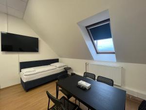 Powder Tower Suites في براغ: غرفة مع طاولة وسرير وتلفزيون