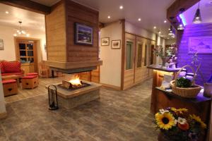a lobby with a fireplace and a living room at Chalet-Hôtel Le Beausoleil, The Originals Relais (Hotel-Chalet de Tradition) in La Toussuire