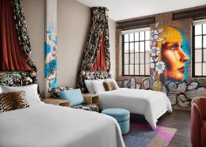 a hotel room with two beds and a mural at The Radical in Asheville