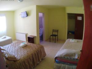 una habitación de hotel con 2 camas y una silla en Lago Buenos Aires en Perito Moreno