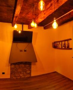 a living room with a fireplace and a flat screen tv at La cascina della vigna del viandante in Abbadia Lariana