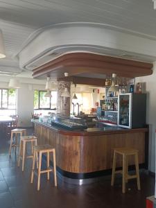 un bar en un restaurante con cuatro taburetes en HOSTAL ALTO PÁRAMO, en Villadangos del Páramo