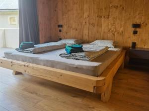 a wooden bed in a room with a wooden wall at Chalet Smreky in Telgárt